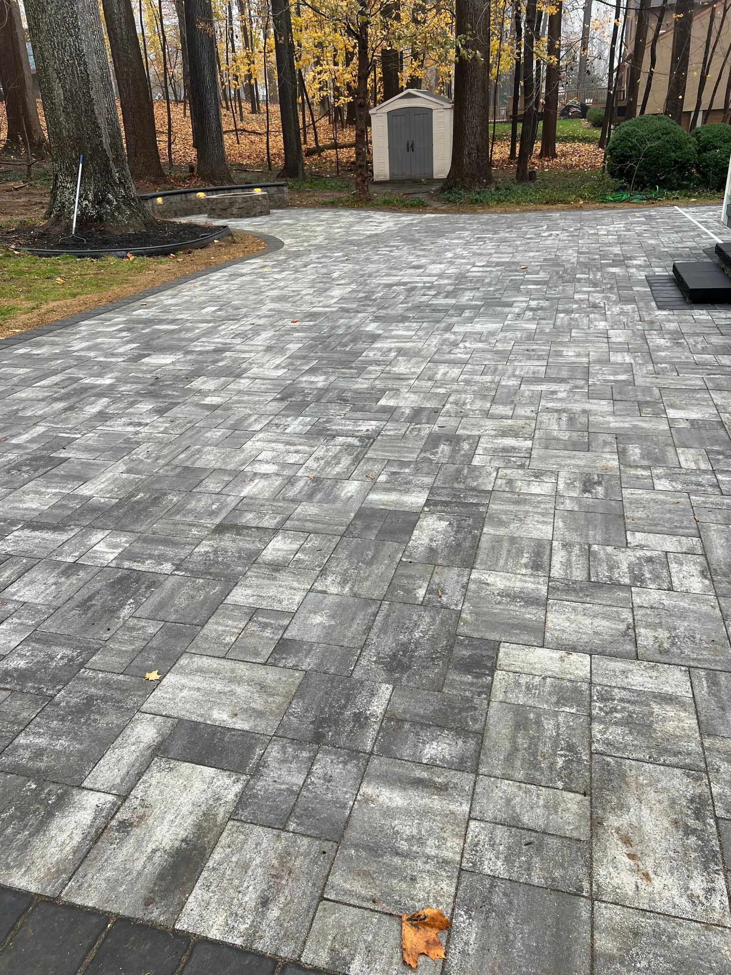 Wide gray paver driveway on a wooded New Jersey lot