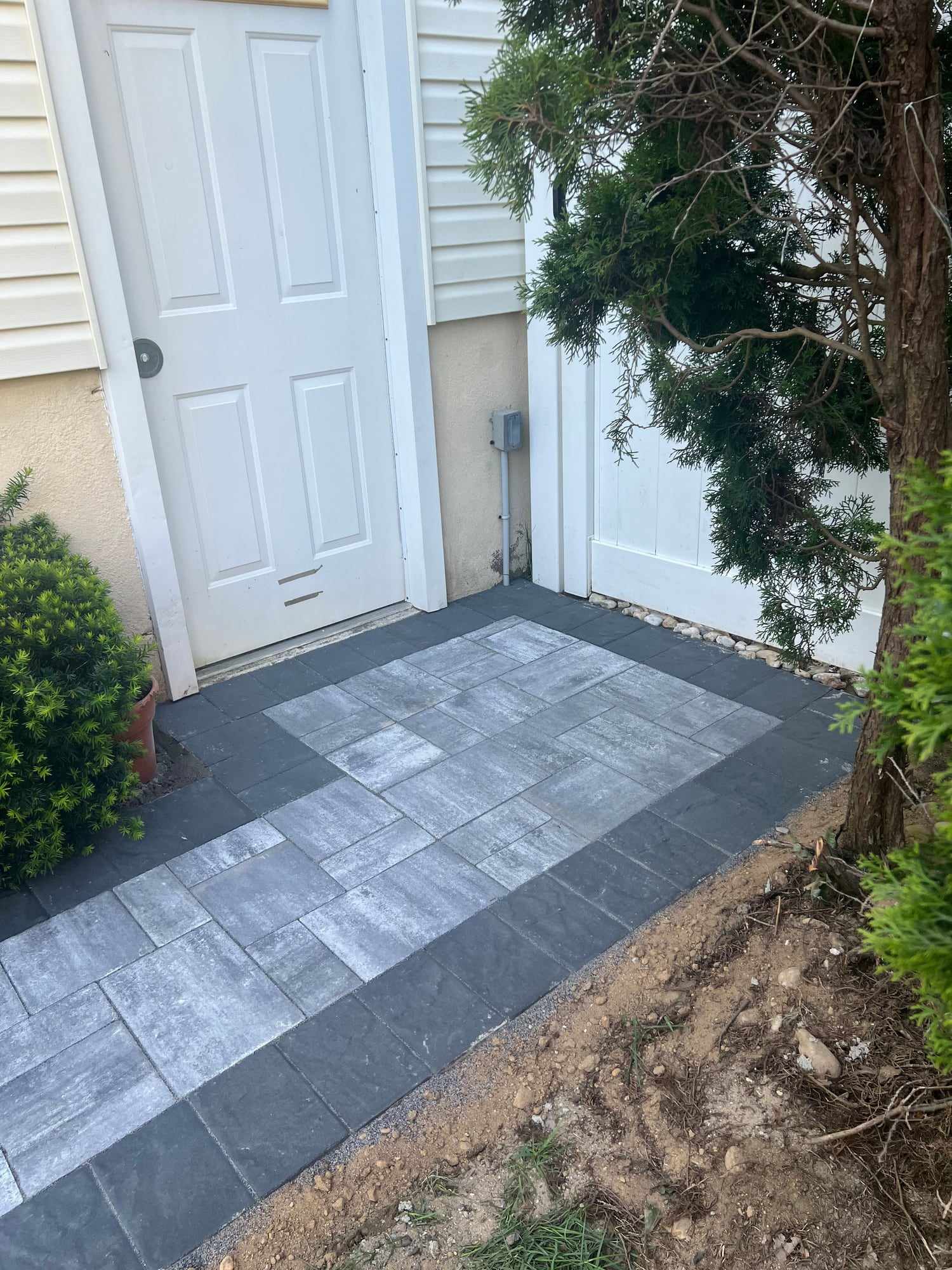 Gray paver landing with a charcoal border at a side door in New Jersey
