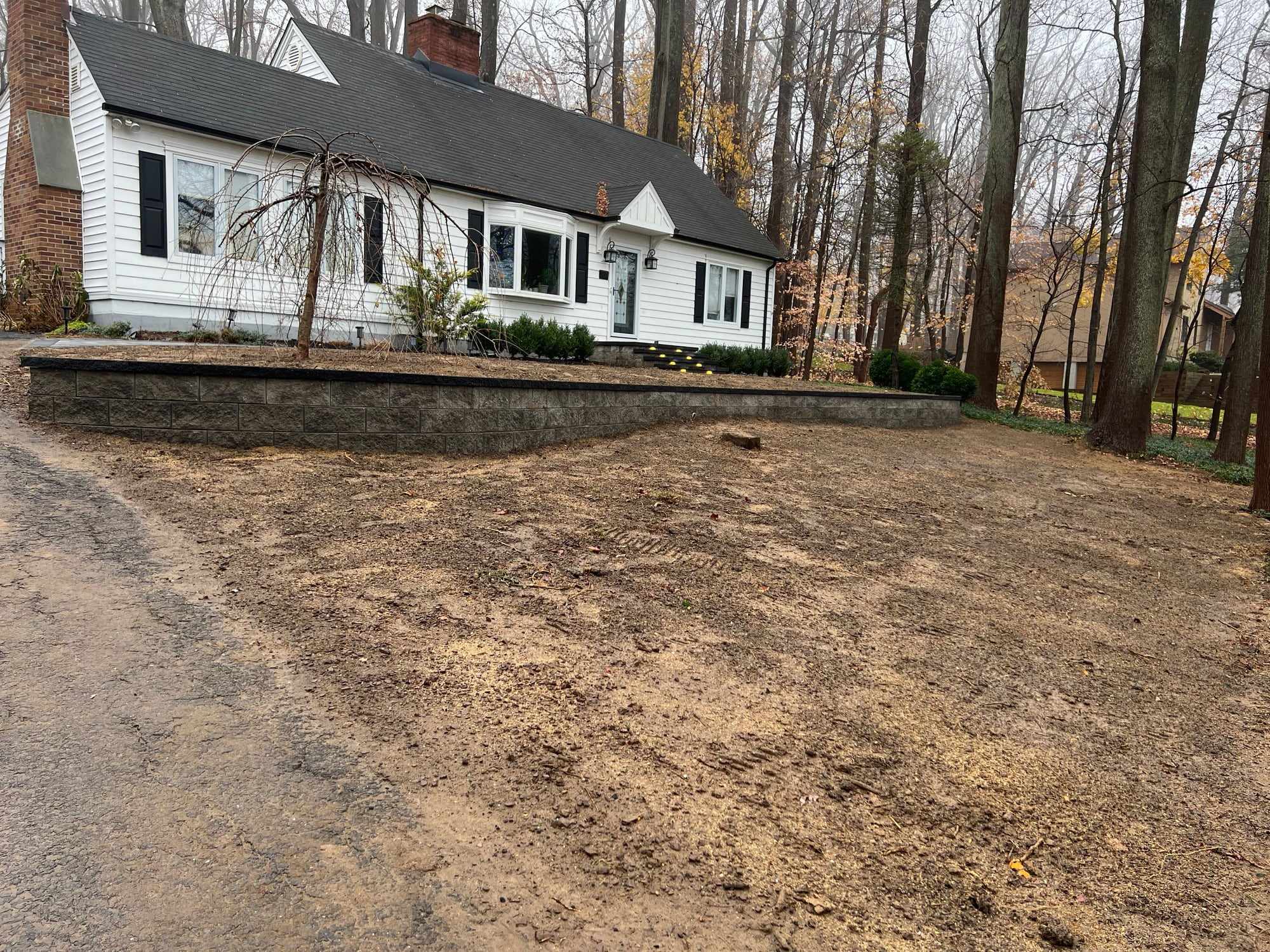 Block retaining wall along a wooded front yard in New Jersey