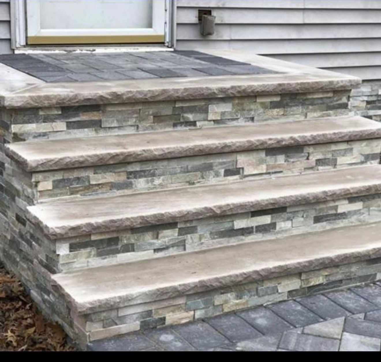 Stacked stone-veneer steps with thick stone treads at a New Jersey home